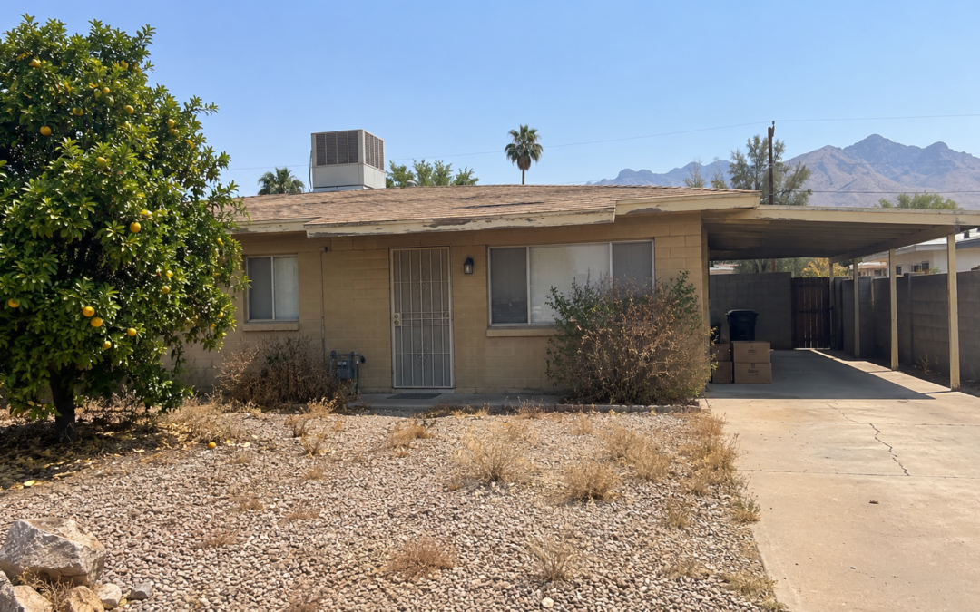Older inherited Phoenix block home with a dry desert yard and moving boxes